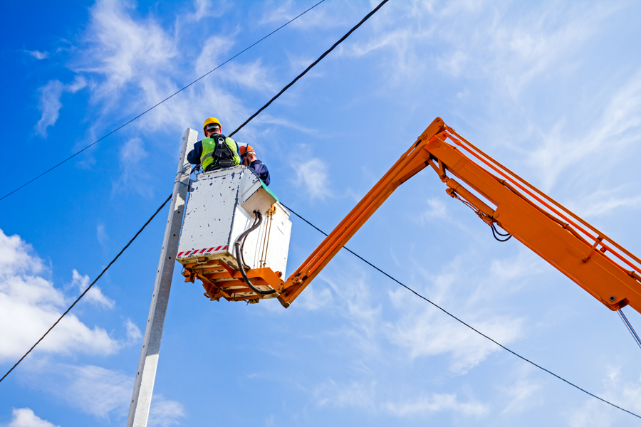 Walker's Electric lineman working from an elevated bucket lift on overhead power lines